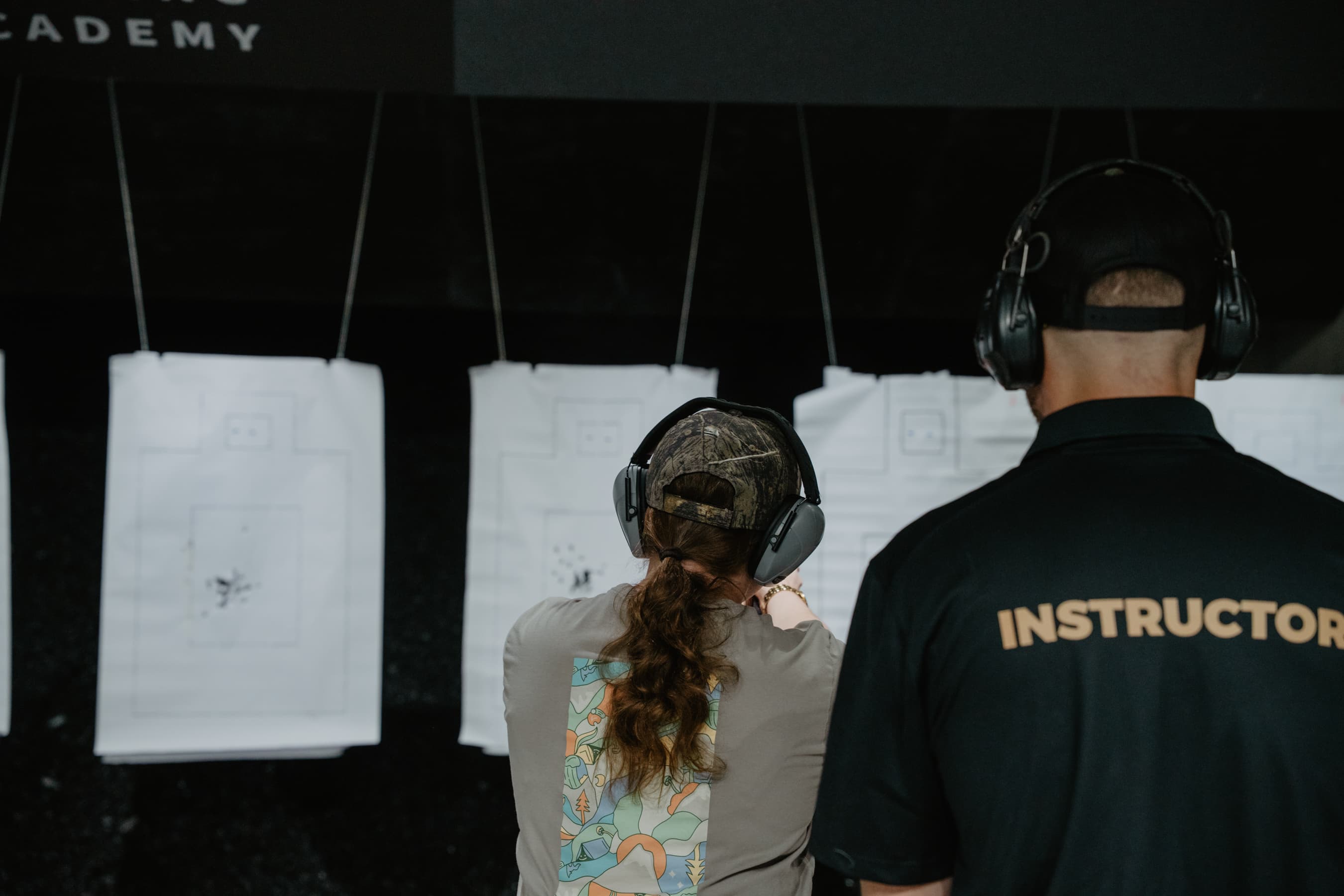 A student and an instructor at the Academy range, working through a drill on paper targets