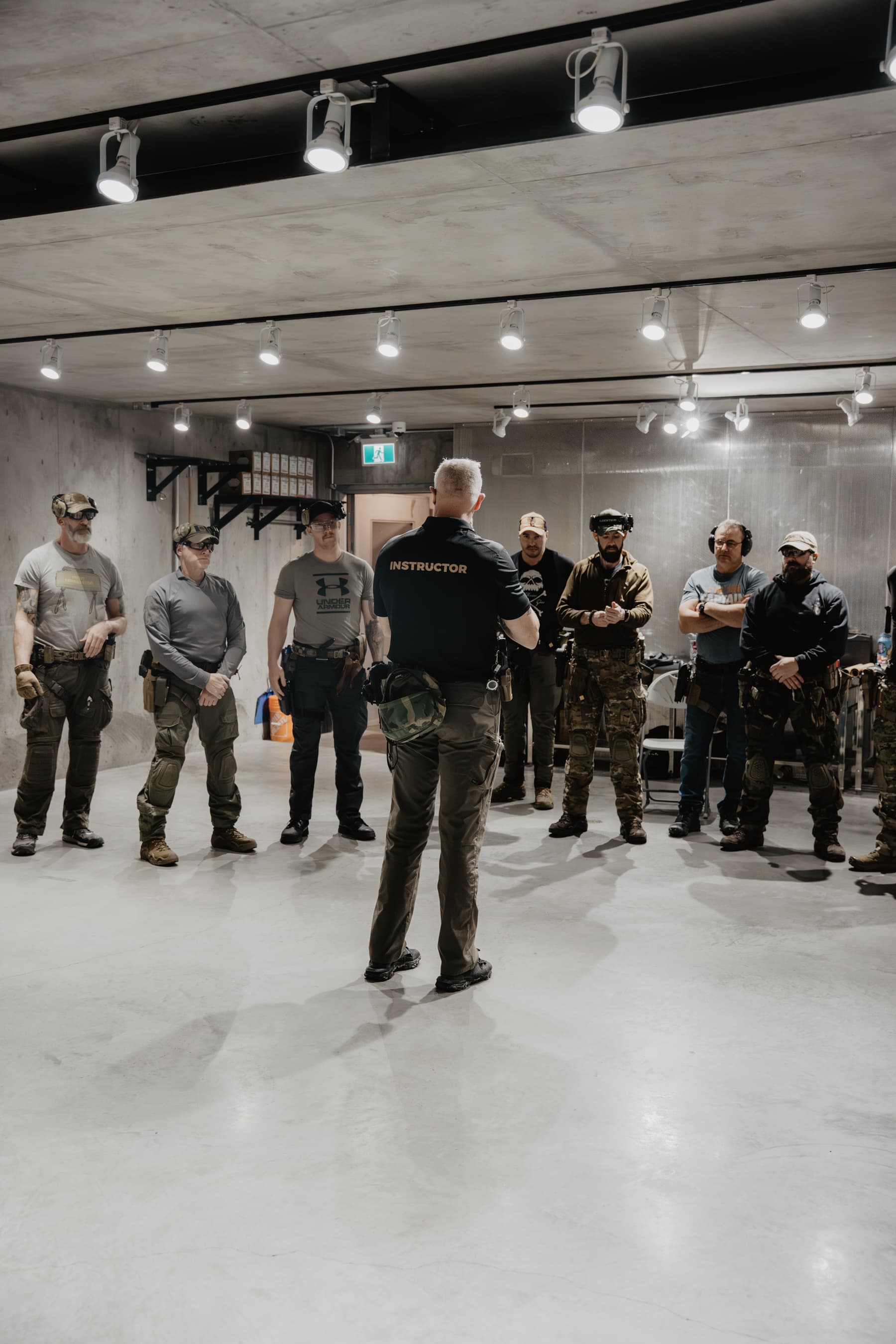 Instructor briefing a small group of students at the indoor range