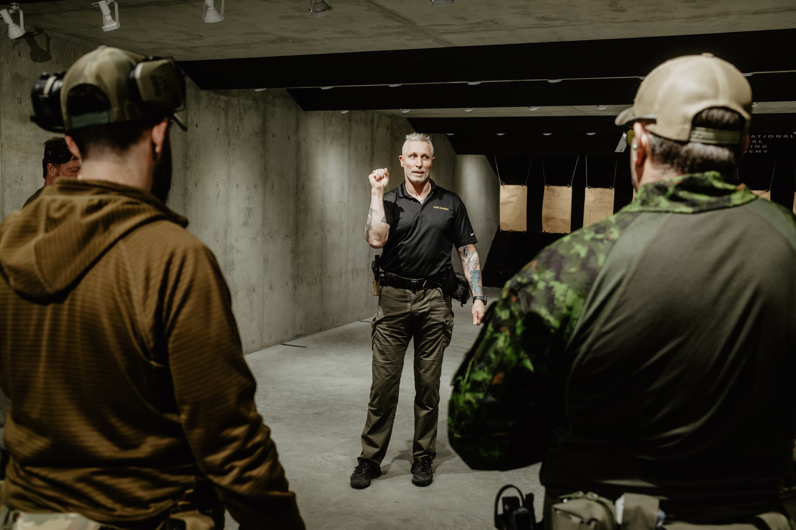 Hazel Academy instructor demonstrating pistol fundamentals to students at the indoor range